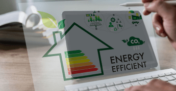 Mão humana de um homem desfocado ao fundo da tela apontando para um ícone de fonte de energia sustentável no centro de um painel eletrônico.