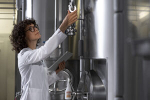 medium-shot-woman-working-beer-factory Central de agua gelada