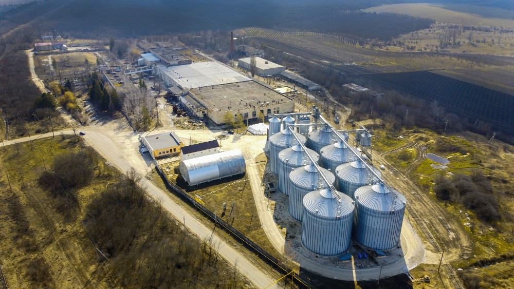 Vista aérea de instalação industrial com tanques metálicos, representando soluções aplicadas na transição energética, como cogeração e uso de biomassa.